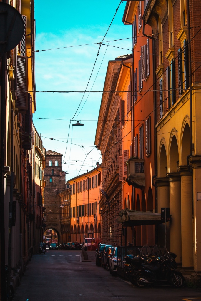 A view down a dark street during golden hour in Bologna, Italy March 2024