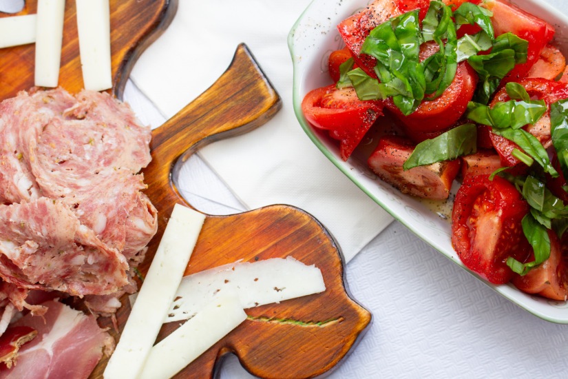 meat, cheese and tomatoes with basil plated on a white table cloth for a street food tasting in Florence, Italy March 2024.