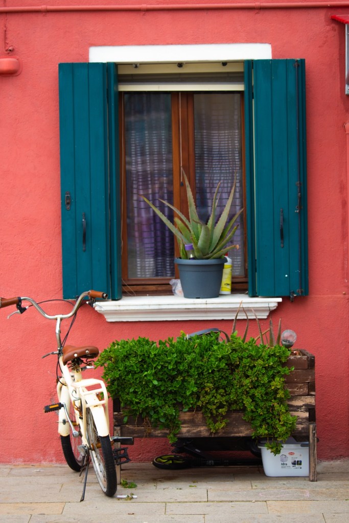 coral colored house in Burano, Italy, March 2024