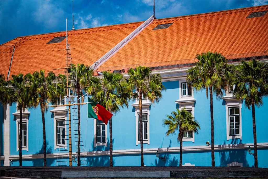 bright blue building and palm trees in Lisbon, Portugal, April 2024